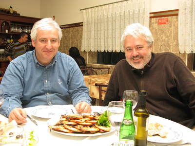 Mauricio and José Gonçalves eating grilled shrimp